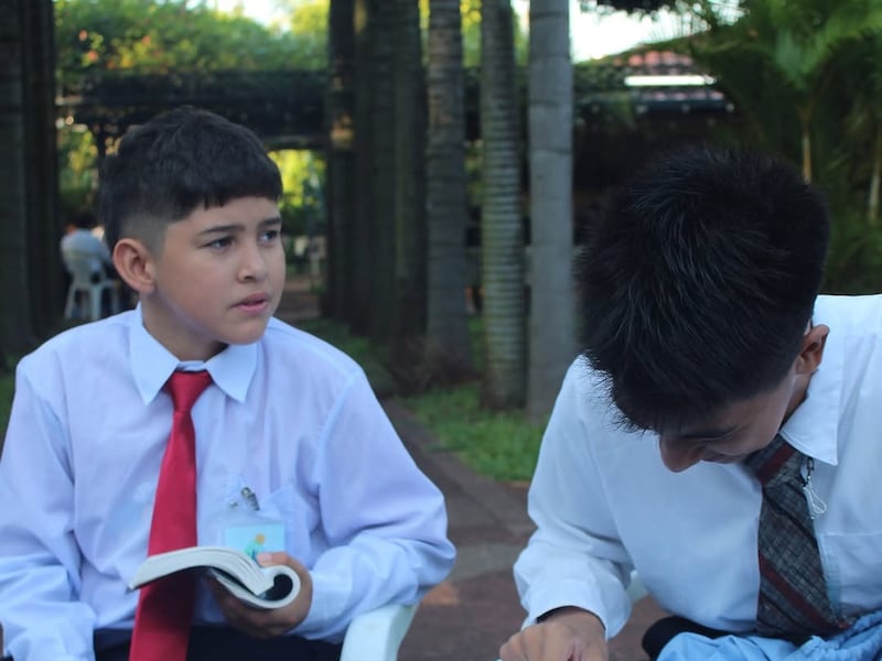 Dos jóvenes estudian las Escrituras en una conferencia Para la Fortaleza de la Juventud en Paraguay en enero de 2026.