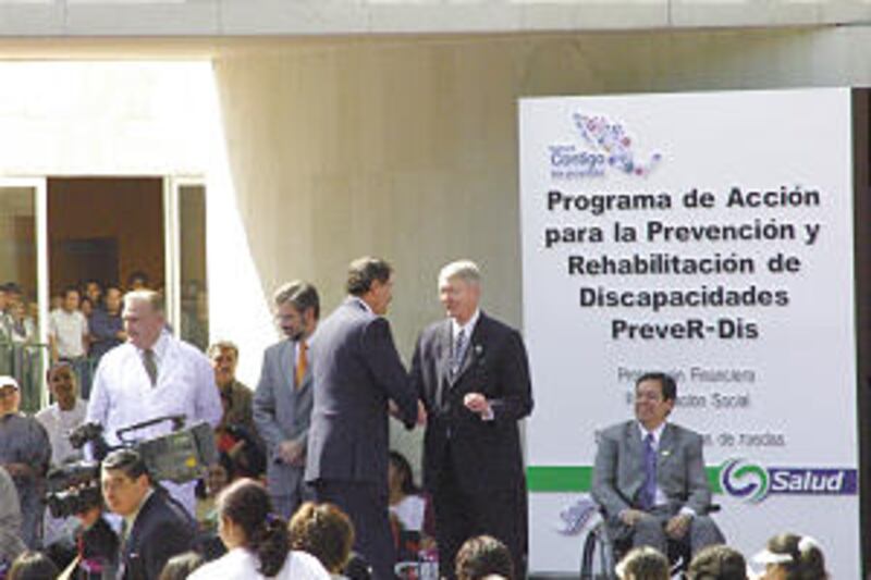 El presidente de México, Vicente Fox, saluda al obispo Richard C. Edgley en la ceremonia de entrega de sillas de ruedas del 10 de diciembre de 2002 en la Ciudad de México, México.