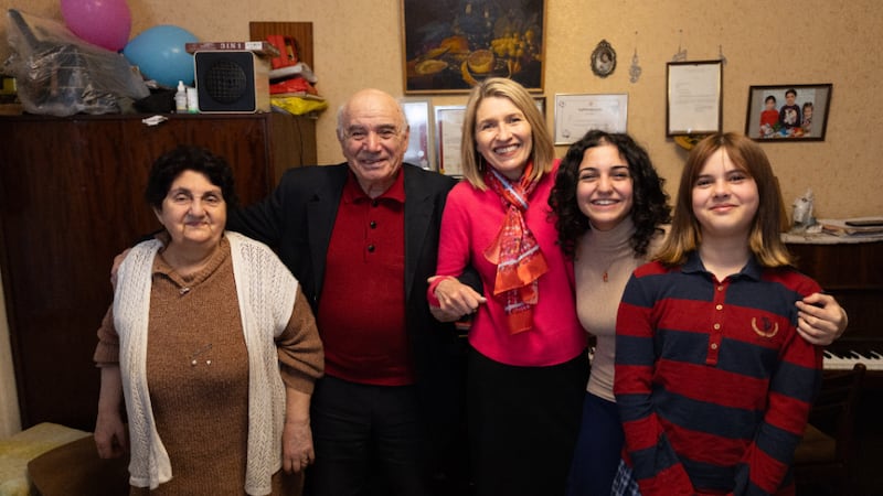 La presidenta Camille N. Johnson posa junto a dos abuelos y sus dos nietas en Tiflis, Georgia, el miércoles 4 de marzo de 2026.