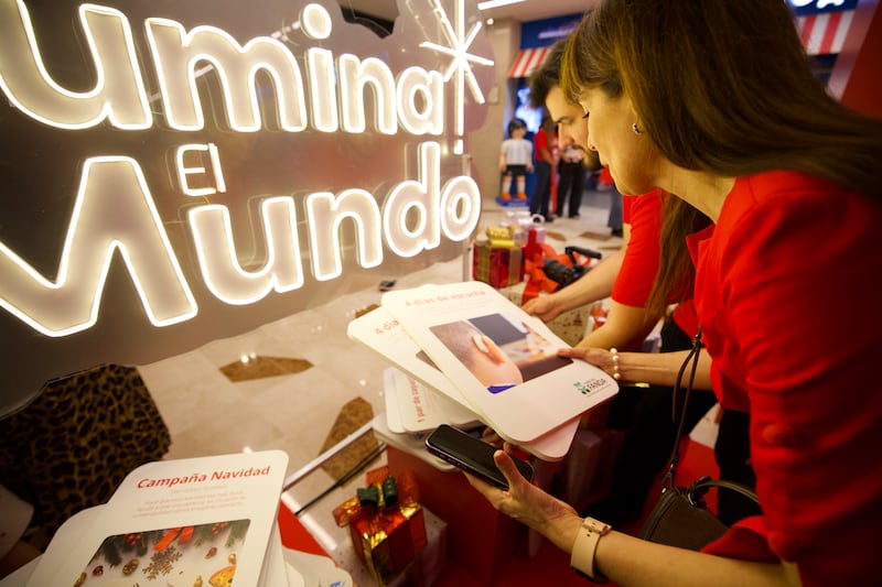 Voluntarios en las Máquinas de Donaciones en Buenos Aires, Argentina, revisan las tarjetas que las personas pueden seleccionar para donar artículos y servicios, el día de la inauguración de las máquinas en Argentina, el 30 de noviembre de 2025.