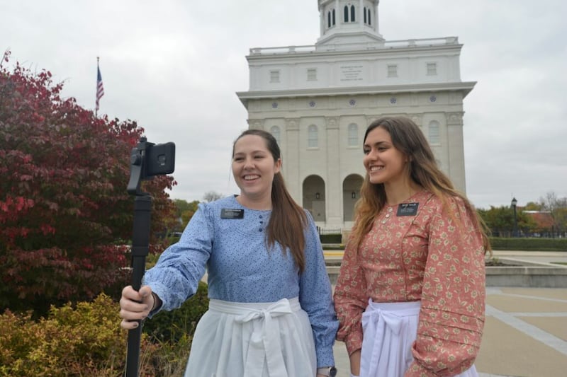 La hermana Karly Robison y la hermana Meg Taylor, misioneras sirviendo en los sitios históricos de Nauvoo, ofrecen un recorrido virtual frente al Templo de Nauvoo, Illinois. Debido a la pandemia del COVID-19, los sitios históricos de la Iglesia han estado cerrados desde marzo de 2020.