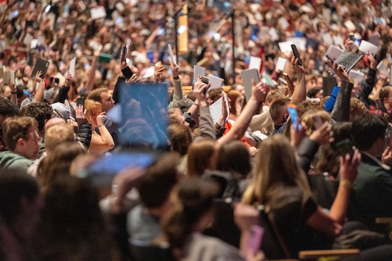 Los alumnos de BYU–Idaho levantan sus cuadernos y dispositivos para tomar notas para mostrar que están preparados para ser enseñados por el élder Aaron T. Hall, Setenta Autoridad General, durante un discurso devocional en Rexburg, Idaho, el martes 3 de marzo de 2026.