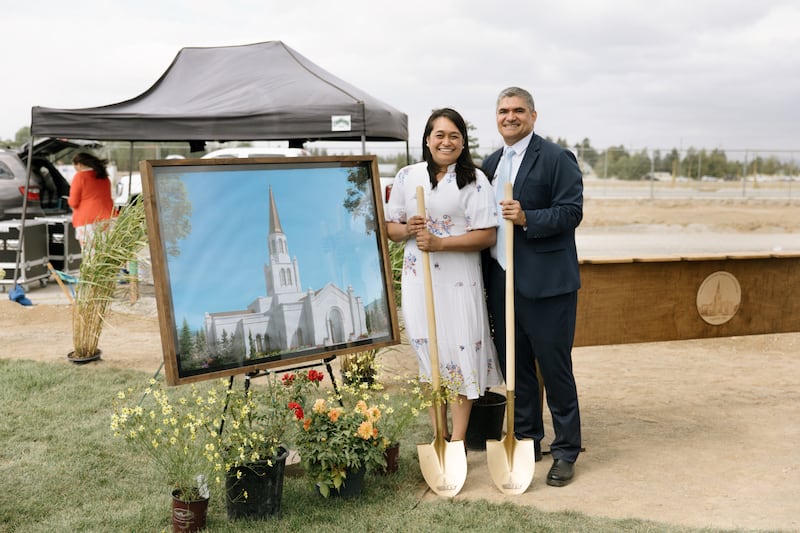 El élder Hutch U. Fale —una Setenta Autoridad General y miembro de la presidencia del Área Oeste de Estados Unidos de la Iglesia— y su esposa, la hermana Gaylene Fale, están de pie junto a un modelo artístico del Templo de Coeur d'Alene Idaho el día de su ceremonia de colocación de la primera piedra el sábado, 29 de agosto de 2026, en Coeur d'Alene, Idaho.