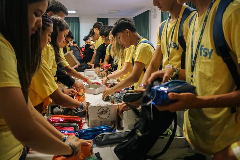 Los jóvenes arman mochilas con útiles escolares para donar a niños necesitados durante FSY en Grosetto, Italia, el 30 de julio de 2025.