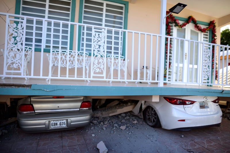 Carros quedan aplastados bajo una casa que se derrumbó después de que un terremoto azotó a Guánica, Puerto Rico, el lunes, 6 de enero de 2020. Un terremoto de magnitud 5,8 azotó a Puerto Rico antes del amanecer el lunes, desencadenando pequeños deslizamientos y causando interrupciones eléctricas y grietas severas en algunas casas. No hubo informes inmediatos de heridos.