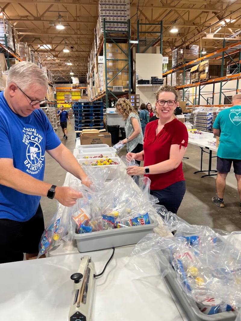 Los amigos y familiares de Gwynne Fullmer empacan bolsas de refrigerios en el Midwest Food Bank en Gilbert, Arizona, el 18 de octubre de 2025, para celebrar el cumpleaños número 70 de Fullmer.