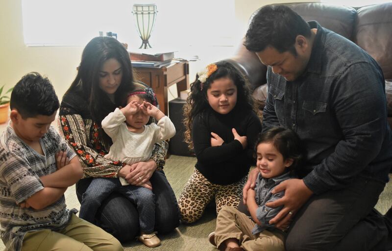Una familia ora unida en un hogar.