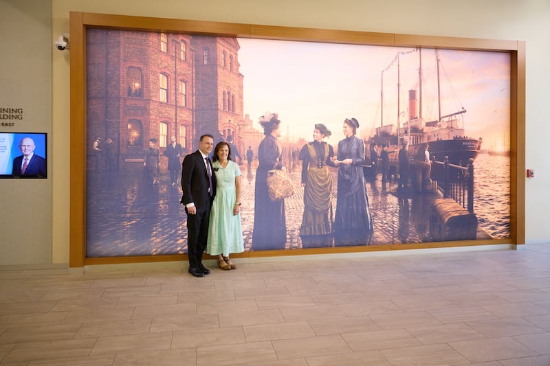 Los nuevos líderes de misión se toman una fotografía junto al mural de las primeras hermanas misioneras solteras en el Centro de Capacitación Misional de Provo.