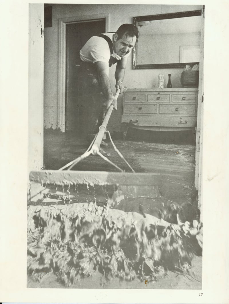 El residente de Rexburg, Idaho, Garrett Case barre el lodo de su casa después de la ruptura de la presa Teton en junio de 1976.