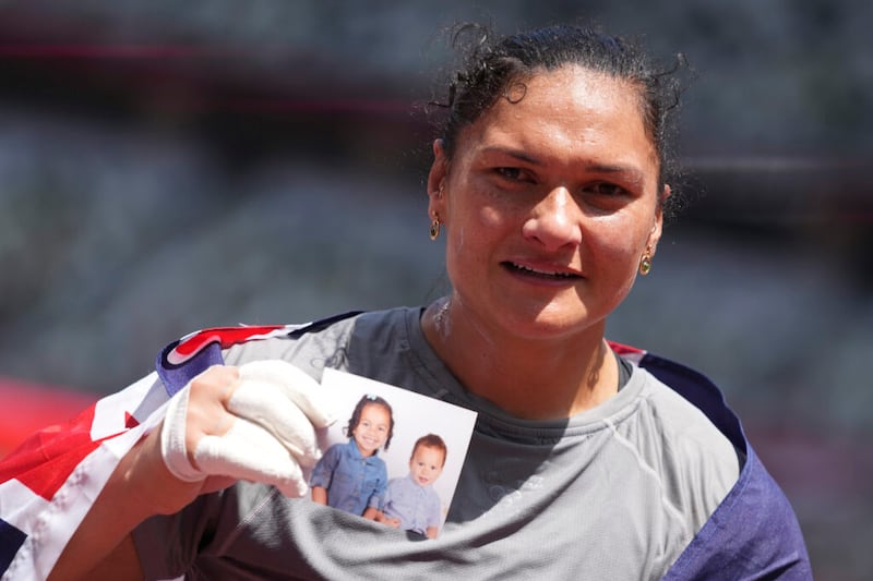 Valerie Adams, de Nueva Zelanda, sostiene una foto de sus hijos mientras celebra su tercer lugar compitiendo en la final de lanzamiento de peso femenino en los Juegos Olímpicos de Verano 2020, el domingo, 1 de agosto de 2021 en Tokio.