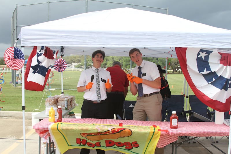 Los misioneros posan frente al puesto de hot dogs en "Fiesta 2026" en San Antonio, Texas, el 11 de abril de 2026. Los misioneros ayudaron con el estacionamiento, sirviendo comida y dando la bienvenida a los asistentes al evento.