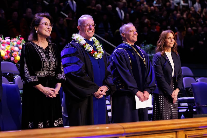 El élder Ulisses Soares, del Cuórum de los Doce Apóstoles, y su esposa, la hermana Rosana Soares, a la izquierda, y el presidente de BYU, C. Shane Reese, y su esposa, la hermana Wendy Reese, a la derecha, participan en la ceremonia de graduación el jueves 23 de abril de 2026 en el Marriott Center, en Provo, Utah.
