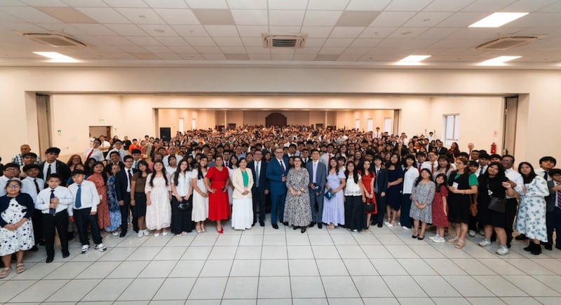 El élder Taylor G. Godoy — Autoridad General Setenta y primer consejero en la presidencia del Área Noroeste de Sudamérica — y la hermana Carol Godoy se toman una foto grupal con los jóvenes, padres y líderes presentes durante un devocional en Lima, Perú, el 11 de enero de 2026.