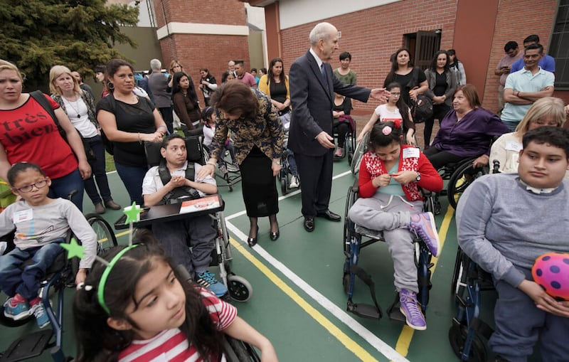 Presidente Russell M. Nelson, de La Iglesia de Jesucristo de los Santos de los Últimos Días, y su esposa, la hermana Wendy Nelson, de pie entre personas que recibieron sillas de ruedas donadas por la organización benéfica Latter-day Saint Charities, en Buenos Aires, Argentina, el miércoles 28 de agosto de 2019.