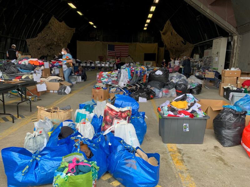 Voluntarios en la Base Aérea Ramstein, en Alemania, organizan artículos donados por la organización Latter-day Saint Charities para los refugiados afganos.