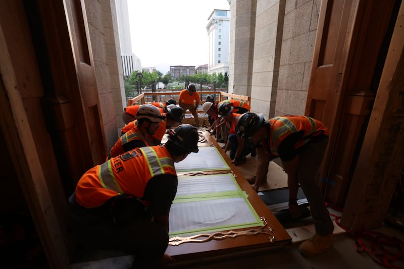 Los trabajadores preparan las puertas del este del Templo de Salt Lake para ser izadas y colocadas en su lugar el martes 23 de junio de 2026.