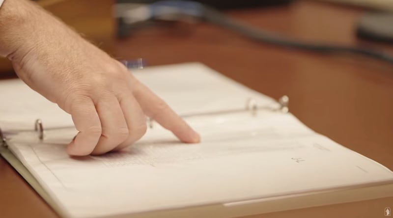 Aaron Kobel, un ingeniero de audio de la Iglesia, examina un libro que registra la altura del púlpito para cada orador en la Conferencia General Anual.
