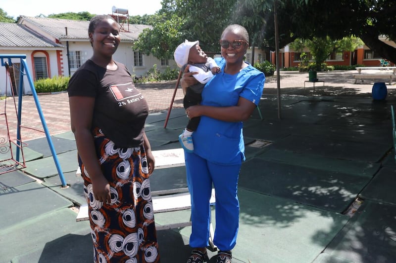 Un bebé de un año se reencuentra con una miembro del personal de la UCIN afuera del Hospital General Lewanika en Mongu, Zambia. El bebé Samuel nació prematuramente en diciembre de 2024.
