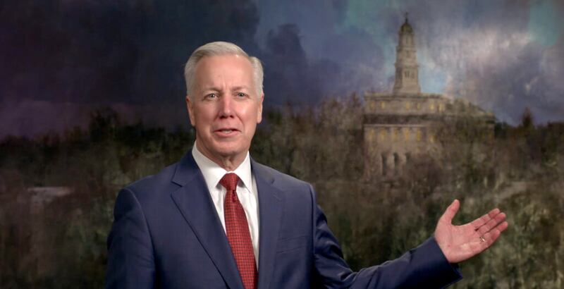 El élder Kevin S. Hamilton habla frente a un mural del Templo de Nauvoo como parte de una sesión de la transmisión de Instrucción para líderes del templo e historia familiar de 2022.