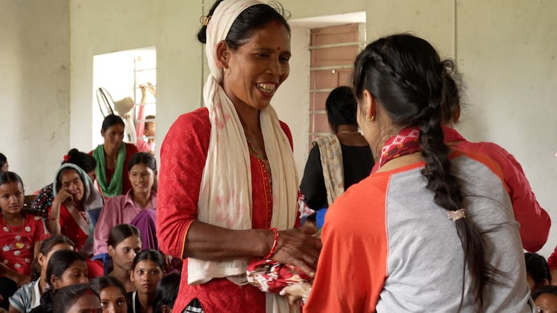 Una mujer en Nepal recibe un kit de salud menstrual de Days for Girls Nepal a principios de mayo de 2025. Estos obsequios fueron posibles gracias a las donaciones realizadas por medio de la iniciativa de las Máquinas Expendedoras de Luz el Mundo, patrocinada por La Iglesia de Jesucristo de los Santos de los Últimos Días.