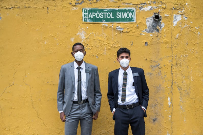El élder Luis Castillo, izquierda, y el élder Isaac Escalante, de la Misión Ecuador Quito, posan frente a una pared mientras caminan por su área en Quito, Ecuador, a fines del verano del 2020. Los misioneros han encontrado formas nuevas y creativas de realizar la obra misional durante la pandemia del COVID-19