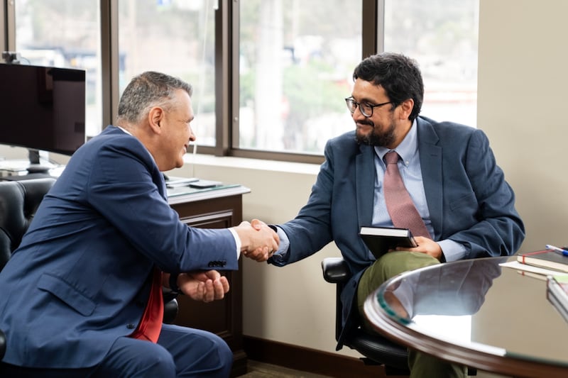 El élder Juan Pablo Villar, Setenta Autoridad General y presidente del Área Noroeste de Sudamérica de la Iglesia, a la izquierda, estrecha la mano de José Fernando Reyes, un funcionario del gobierno del Perú, después de entregarle un ejemplar del Libro de Mormón en Lima, Perú, el 3 de febrero de 2026.