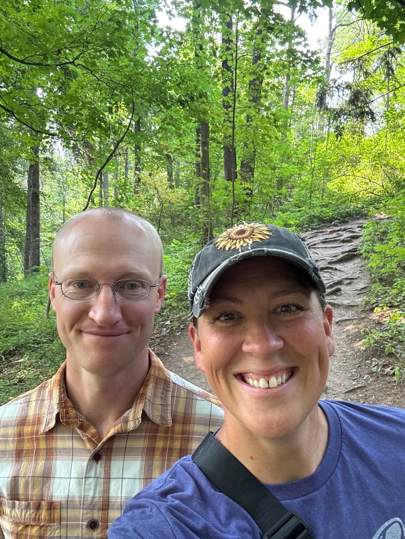 Glenn y Erica Nielson se encuentran afuera juntos frente a un camino de tierra.