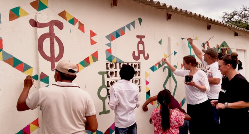 Los voluntarios de WaterAid junto con miembros de la comunidad Wayúu pintan símbolos antiguos de "Kanaas" en la nueva infraestructura de agua en La Guajira, Colombia, en un video de Youtube publicado el 3 de febrero de 2025.