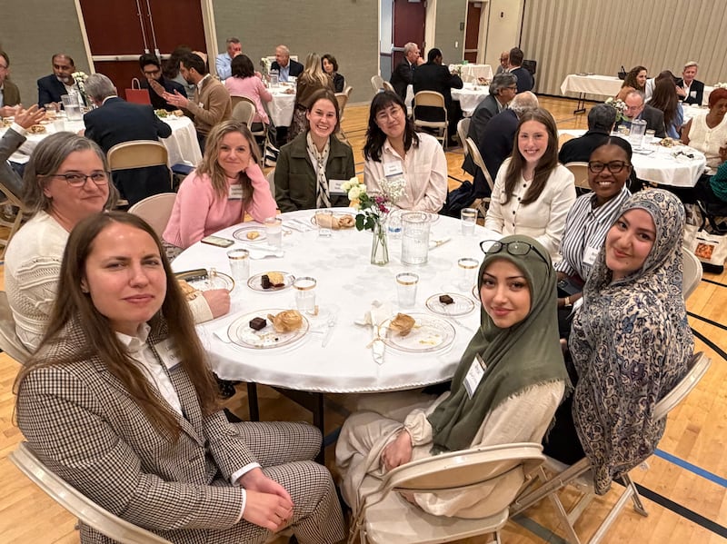 Las mujeres se sientan en una mesa para compartir una comida juntas en una reunión interreligiosa en Chicago, Illinois, el 14 de octubre de 2026.