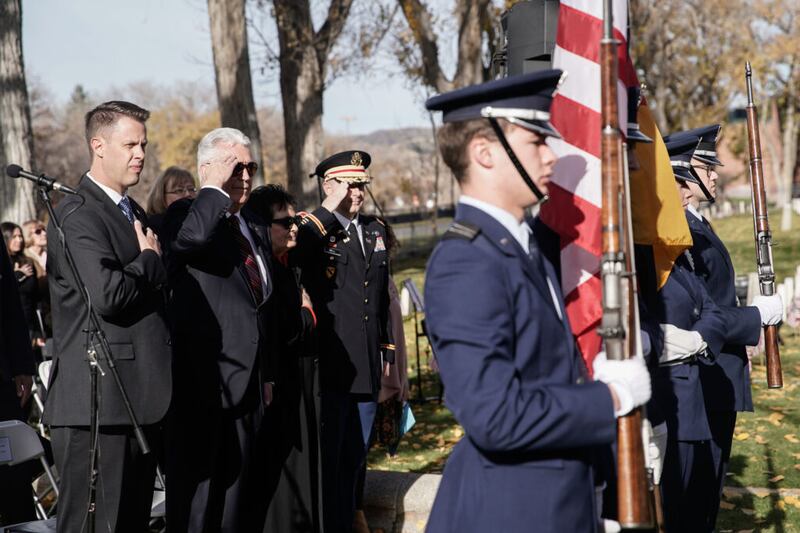 El élder Dieter F.Uchtdorf, en el centro, y su esposa, la hermana Harriet F.Uchtdorf, el cónsul honorario de Alemania James T. Burton, a la izquierda, muestran su respeto mientras participan en el evento Volkstrauertag en el cementerio militar de Fort Douglas el domingo, 14 de noviembre de 2021 en Salt Lake City.