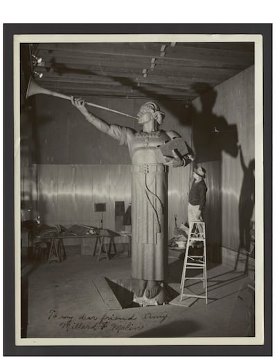 Millard F. Malin sobre una escalera al lado de su estatua del ángel Moroni, aproximadamente 1956. Esta estatua se colocó en el Templo de Los Ángeles, California.