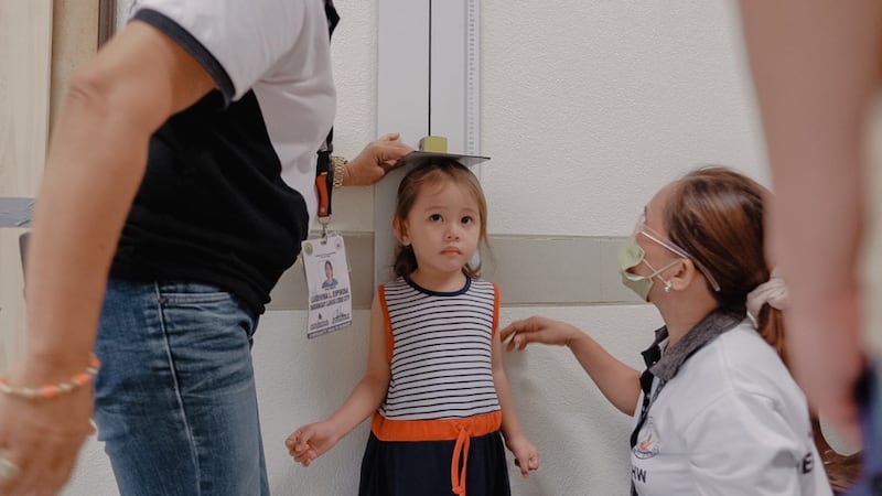 Trabajadores de la salud miden la estatura de un niño durante una evaluación en la ciudad de Cebú, Filipinas, el 16 de agosto de 2022.
