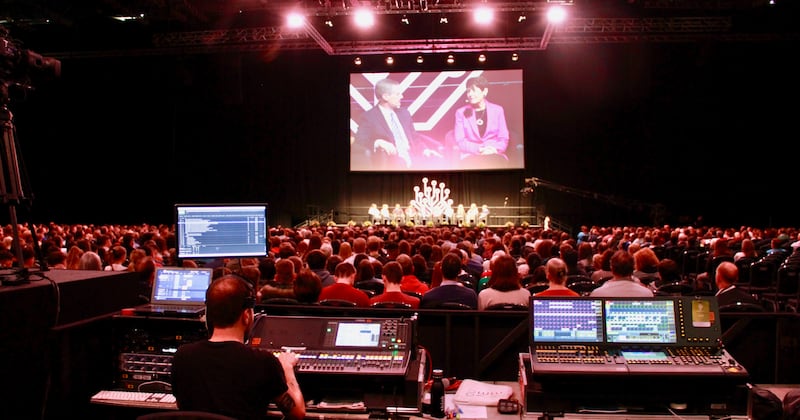 El élder David A. Bednar y la hermana Susan Bednar aparecen en la pantalla mientras ocho jóvenes participan del panel de discusión “Experiencia juvenil” con los Bednar durante el evento RootsTech Londres, el sábado 26 de octubre de 2019.