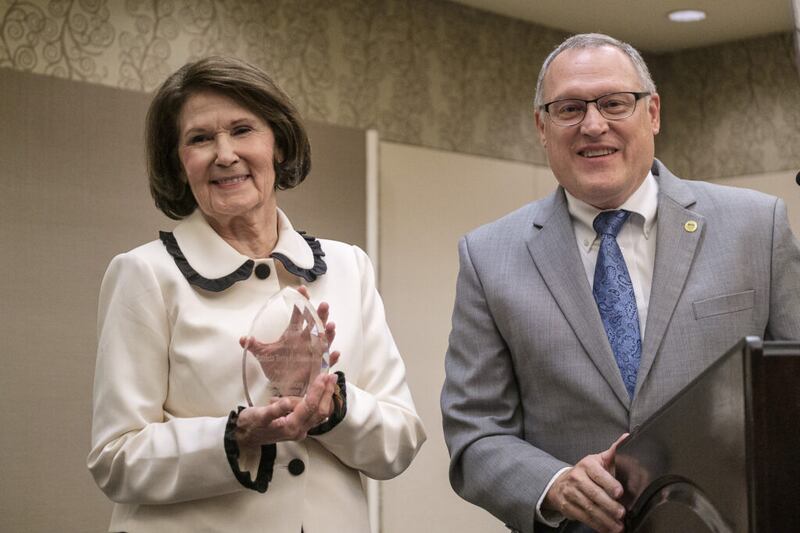 La hermana Patricia Terry Holland, a la izquierda, reacciona al recibir el premio Dixie Heritage Distinguished Public Service Award otorgado por Brian Tenney, presidente de la sección St. George de la Sociedad de Gestión Administrativa de BYU, durante el BYU Management Society Scholarship Banquet 2021 el viernes, 5 de noviembre de 2021. en St. George, Utah.