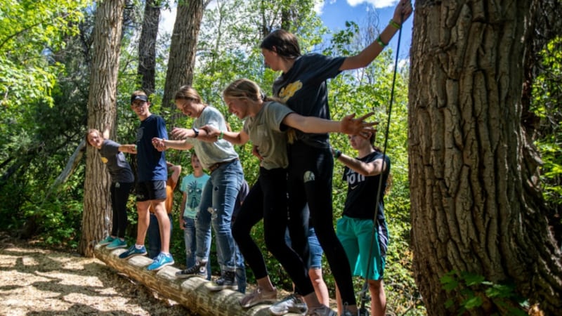 Jóvenes mujeres y jóvenes hombres de La Iglesia de Jesucristo de los Santos de los Últimos Días participan en una actividad al aire libre.