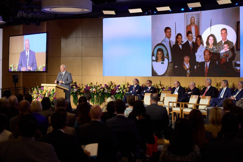 Mostrando una foto familiar de su época como presidente de misión a finales de la década de 1990, el élder Ronald A. Rasband, del Cuórum de los Doce Apóstoles, habla durante el Seminario para Nuevos Líderes de Misión 2022 el viernes, 22 de junio de 2022 en el Centro de Capacitación Misional de Provo.