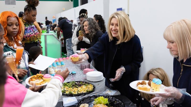 La Presidenta Camille N. Johnson sirve comida a madres nuevas y embarazadas en Chicago durante un baby shower de MOMS.