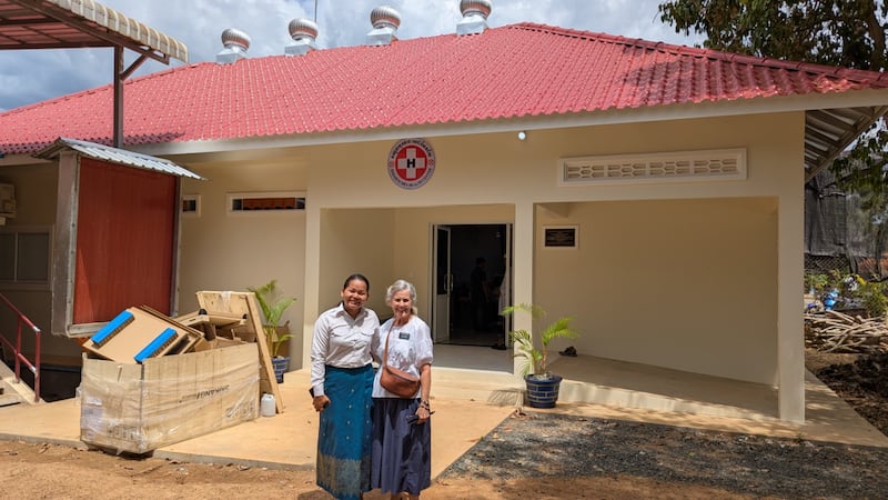 La hermana Marvel Earnshaw, a la derecha, posa para una foto frente al Centro de Salud Seda Senchhey en Tboung Khmum, Camboya, donde la Iglesia donó equipos médicos el 7 de junio de 2025.