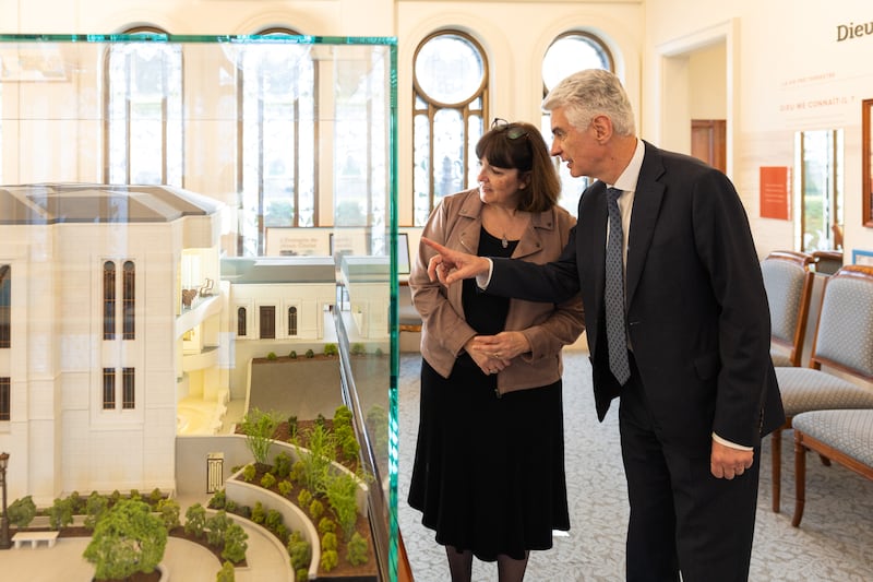 El élder Gérald Caussé, del Cuórum de los Doce Apóstoles, y su esposa, Valérie, observan una maqueta del Templo de París Francia en el Centro de Visitantes de París Francia en Versalles, Francia, el viernes 27 de febrero de 2026.