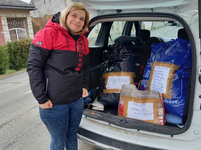 Un miembro de la Sociedad de Socorro en Pécs, Hungría, muestra artículos donados recolectados en marzo de 2022 para un proyecto de servicio que conmemora el 180.º aniversario de la Sociedad de Socorro.