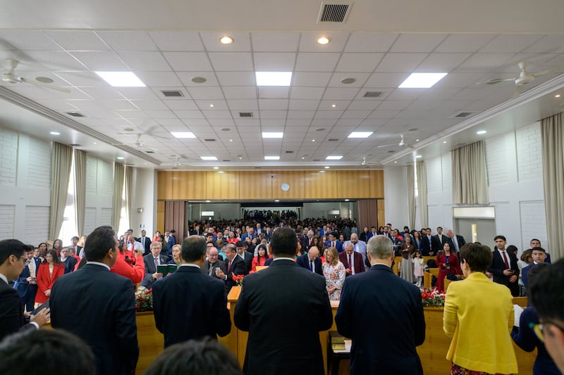 El élder David A. Bednar, del Cuórum de los Doce Apóstoles, segundo desde la derecha, se pone de pie con la congregación durante una reunión de la conferencia de estaca Colina Chile en Santiago, Chile.