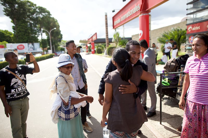 Un misionero que regresa saluda a amigos y familia fuera del aeropuerto en Madagascar en 2026.