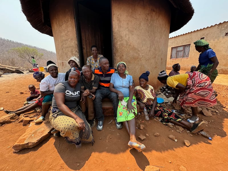 Kilford Shereni, al centro, se sienta con familiares y amigos en el kamusha familiar —que significa "hogar" o "origen" en el idioma shona—.