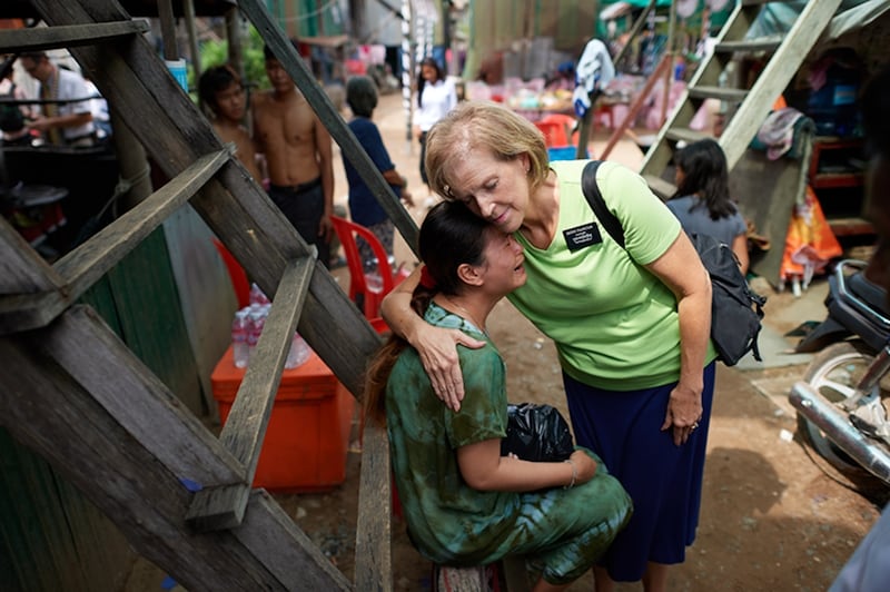 Una misionera mayor abraza a una mujer en Camboya en 2024.