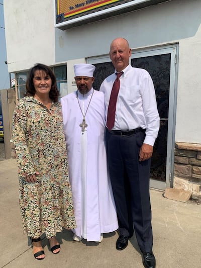 Kris y Dan Beech con el Padre Fisehatision, Iglesia Tewahedo Ortodoxa Etíope Santa María de Utah, en Layton, Utah.