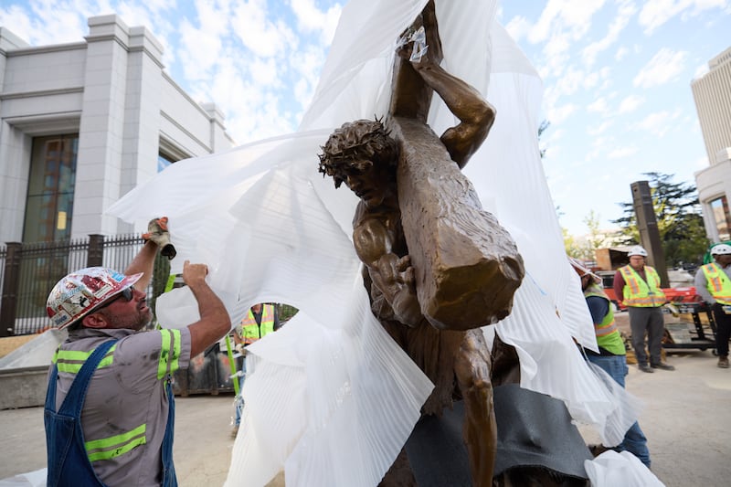 Los miembros del equipo instalan la estatua "Jesucristo llevando la cruz", creada por Michael Hall, justo al sur del Templo de Salt Lake, el miércoles 17 de septiembre de 2025.