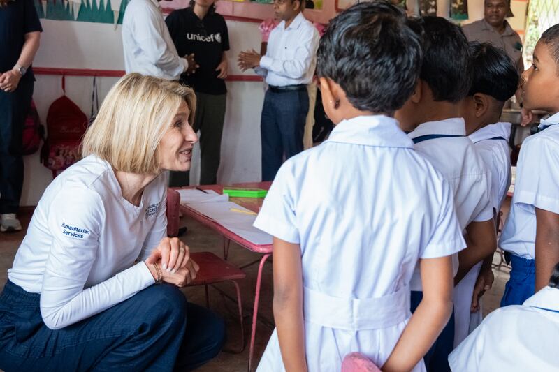 La Presidenta General de la Sociedad de Socorro, Camille N. Johnson, visita a jóvenes estudiantes con uniformes en una escuela de Sri Lanka.