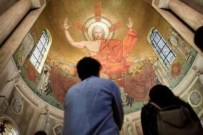 Un grupo con la Iglesia de Jesucristo de los Santos de los Últimos Días se encuentra debajo del mosaico “Cristo en Majestad” en el ábside norte de la iglesia superior durante un recorrido por la Basílica del Santuario Nacional de la Inmaculada Concepción, en Washington, D.C., el 19 de marzo de 2022.