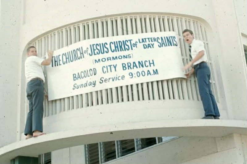 Los misioneros colocan una pancarta en una capilla alquilada en el edificio Correa, ubicado en la esquina de las calles Araneta y Rosario; fue uno de los lugares donde los Santos de los Últimos Días se reunían para la reunión sacramental en la década de 1970, en la Ciudad de Bacolod, Filipinas.