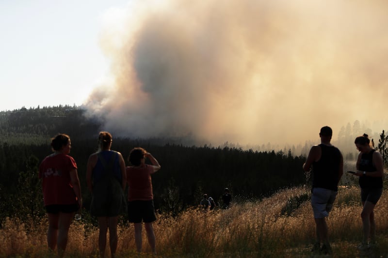 Personas observan el incendio Old Trails desde W. Northwest Blvd., sábado 1 de agosto de 2026, en Spokane, Washington.